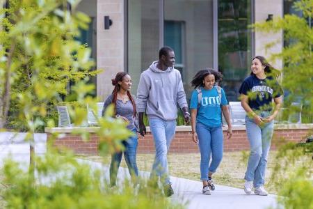 A group of students walking in front of Owens House residence hall